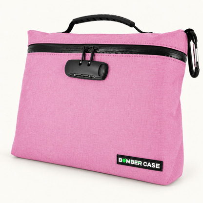 Pink XL Bomber Case locking bag with top handle, combination lock and side carabiner on an ivory background.